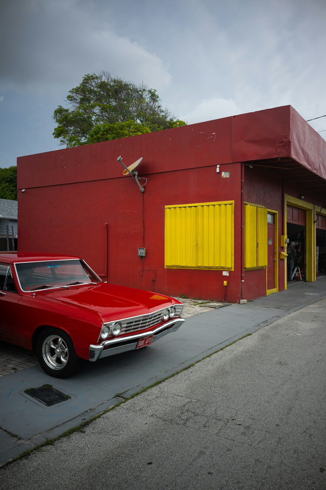 Classic car parked in front of a workshop