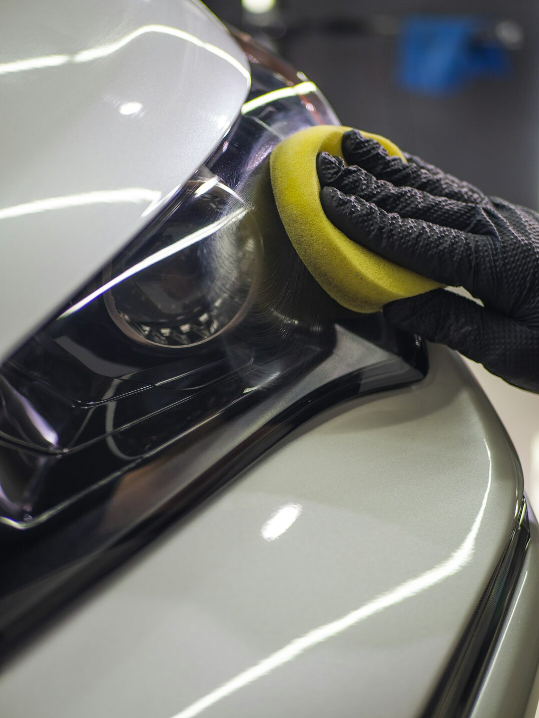 Technician applying polish to a car body panel